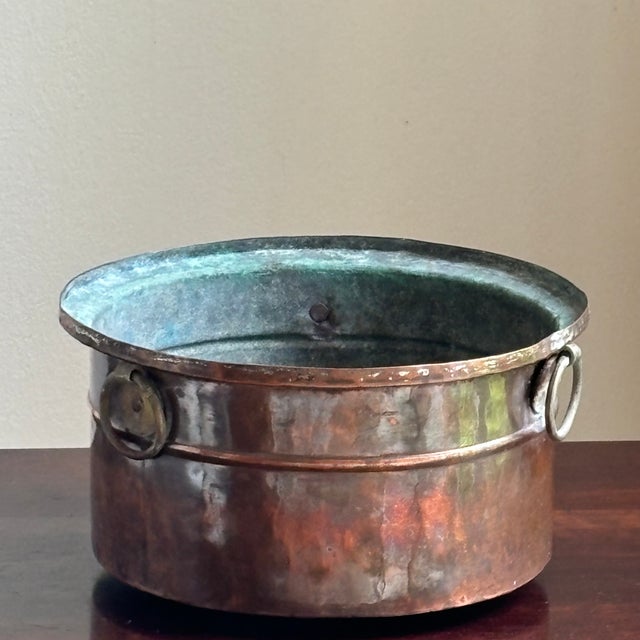 Offering a small antique tinned copper pot with three heavy-duty ring handles. Historically used for everyday cooking,...