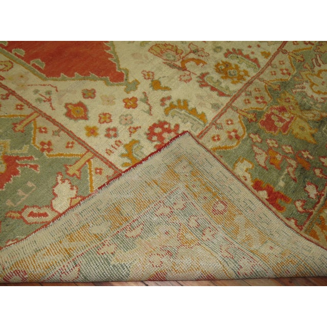 A truly divine antique Oushak masterpiece. Two identical scrolls in between an irregular set of palmettes running through...