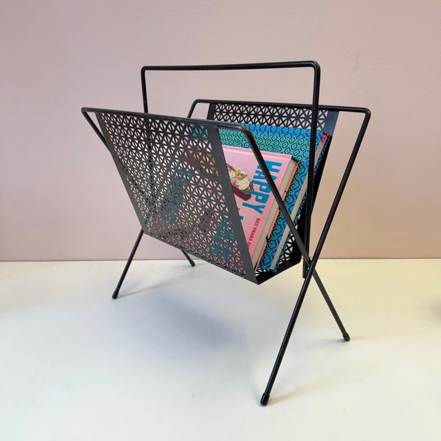 A stunning classic 1950/60’s black perforated metal magazine rack with black rod frame. Dimensions: 16.75”W x 10.25”D x 18”H