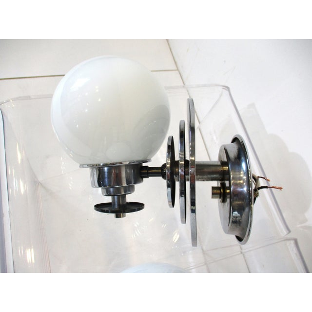 A pair of chromed Art Deco sconces with stacked circlular discs having opaque white glass globe shades . Ready to mount in...