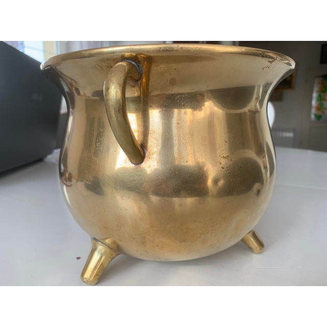 A brass signed vessel from the 19th century. The container inside has an embossed, bulging Marking of a cat with a raised...