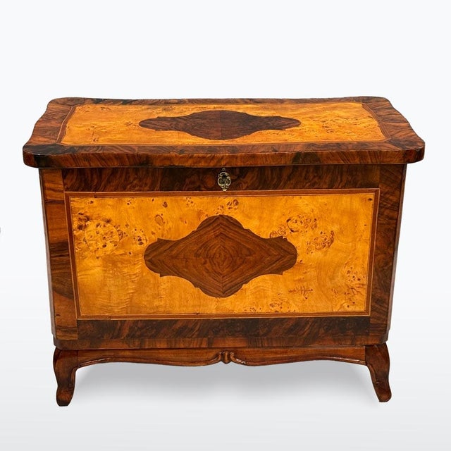A representative chest in the Neo-Baroque style featuring stunning burl veneer, inlays, and rich decorative elements....