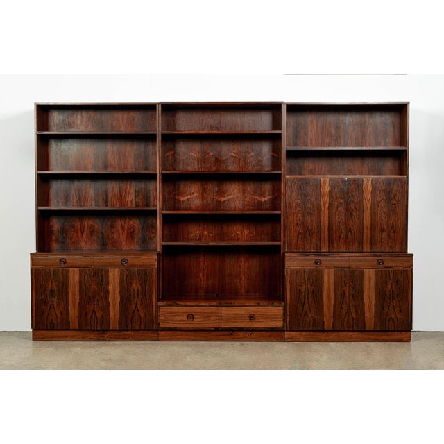 This impressive vintage Swedish mid-century modern three-section bookcase cabinet system was designed by Bertil Fridhagen...