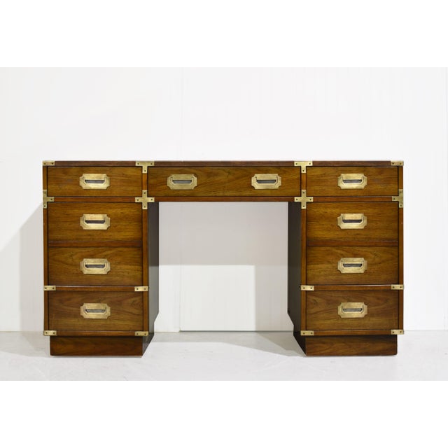 Mid century Campaign desk by Bernhardt Furniture has a rectangular top, warm brown wood finish and grain across its drawer...