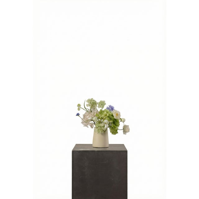 A soft, layered arrangement featuring cream peony, green and cream hydrangea, and delicate Queen Anne’s lace. Light...