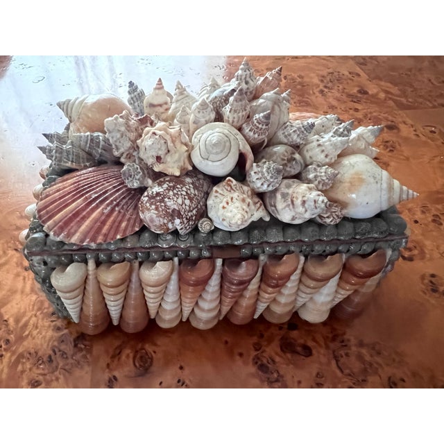 This is a gorgeous shell encrusted box with a hinged lid. The surface is densely decorated with real shells and the...