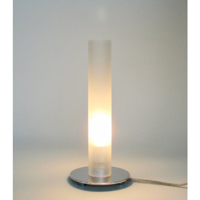 Small table lamp with tubular frosted glass shade on round chrome base by Ligne Roset. Switch is on the cord.