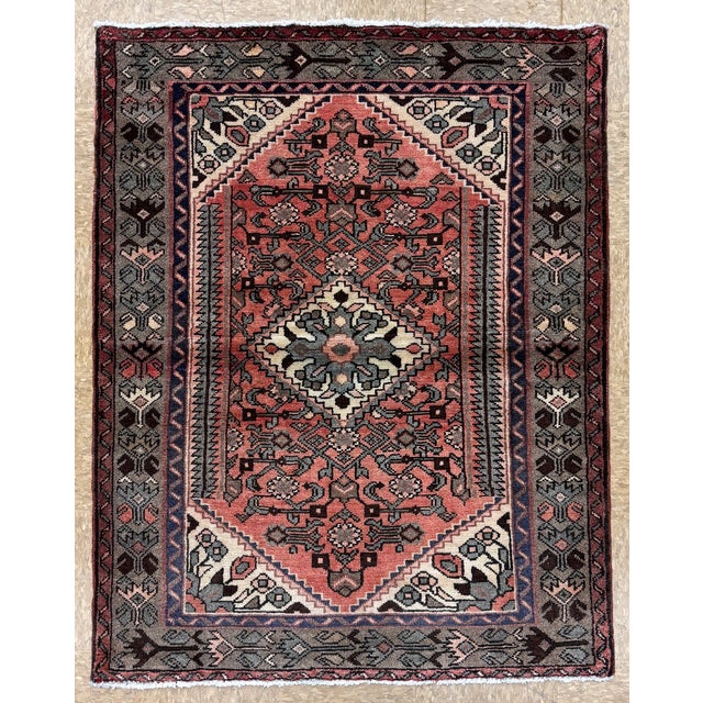 Hand-knotted village rug from the Hamadan region of western Iran, featuring a large geometric medallion set within a rose...