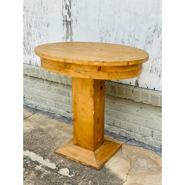 A charming antique pine pedestal table featuring a warm natural finish and beautifully aged patina. Its simple oval top...