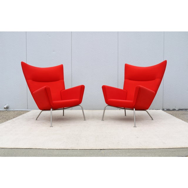 Fabulous mid-century modern pair of CH445 Wing lounge chairs in red wool fabric, designed by the famous Danish designer...