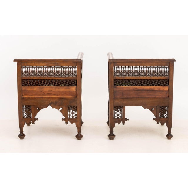 Pair of Syrian Bone Inlay Walnut Corner Chairs, with carved openwork backrests, the seat with single pull drawers on four...