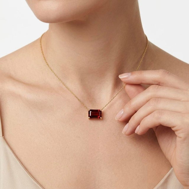 Make a bold yet sophisticated statement with this striking East-West Emerald Cut Red Gemstone Necklace. This piece...