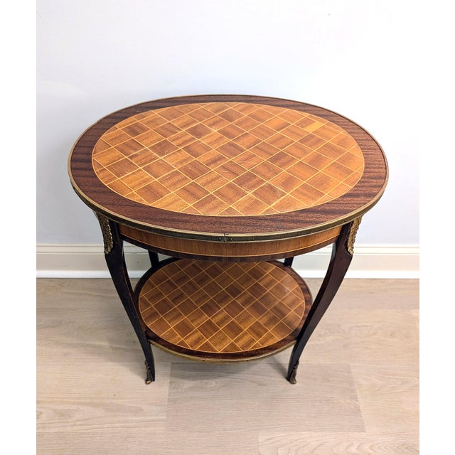 This elegant piece is a Louis XV style oval side table, featuring a diamond/cube parquetry inlay. It is a "transitional"...