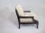 Modern lounge chair with upholstered seat and back cushion. The finish is a darker walnut. He chenille is a cream color....