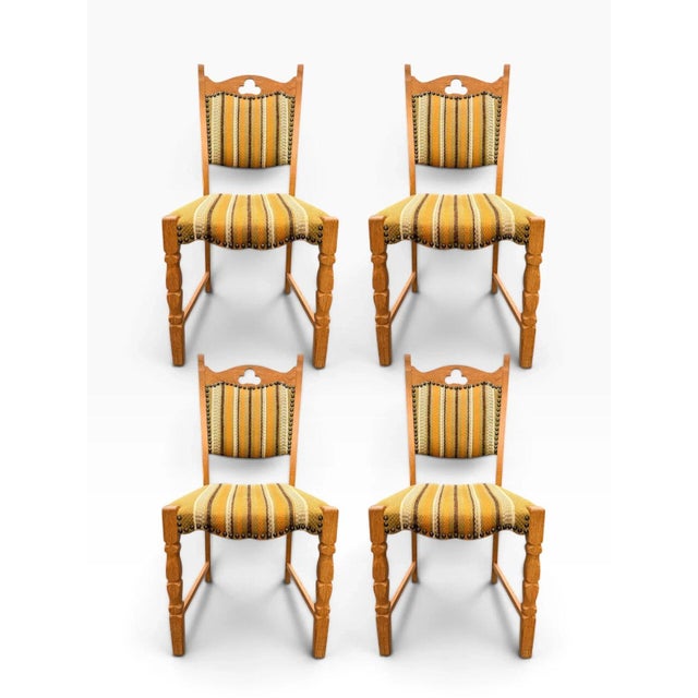 Here is a set of seven Danish modern dining chairs designed by Henning Kjærnulf: one captain's armchair and six side...
