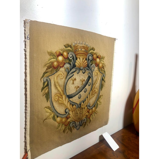 Hand woven 100% wool tapestry fragment with embellished crest design in tones of soft blue, sand and butterscotch....