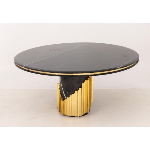 Luxxu "Littus" Black Marble Dining Table, the circular top above cylindrical base with gilt metal details. 30.5" H x 62.5"...