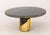 Luxxu "Littus" Black Marble Dining Table, the circular top above cylindrical base with gilt metal details. 30.5" H x 62.5"...