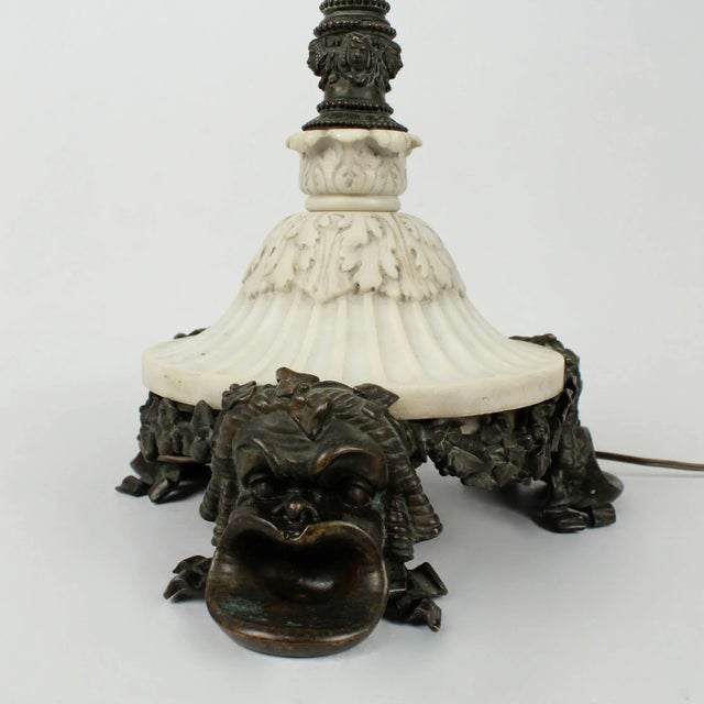 An antique E. F. Caldwell bronze and marble table lamp of exceptional quality. Feet modeled as Greek masks support a round...