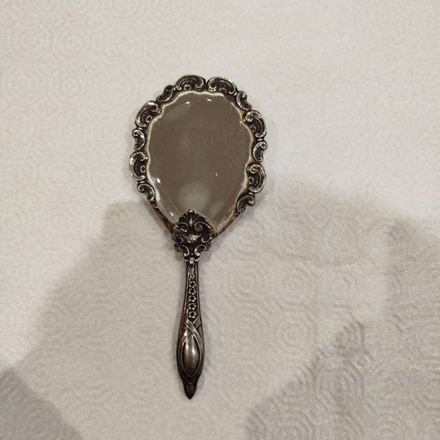 Silver Hand Mirror. 77 grams. Height: 6.89 in (17.5 cm) Width: 2.96 in (7.5 cm) Depth: 0.4 in (1 cm) This piece has an...
