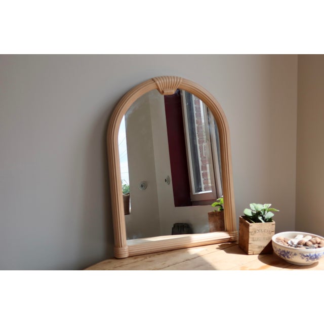 Arched portrait-style wall mirror with a molded frame tinted in an elegant powder pink. Its design of repeated fluting and...