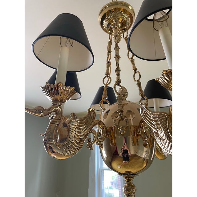 A striking solid brass swan‑arm chandelier featuring six sculpted bird figures, warm polished brass, and elegant black...