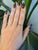 A rare demantoid garnet glows in a vivid, fiery green at the center of this solid 14K rose gold ring, flanked by four...