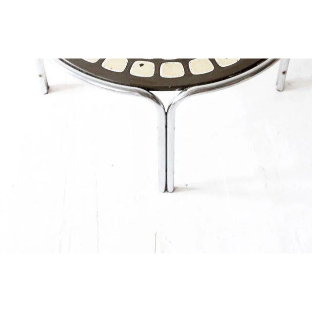 1970s retro coffee table with a mandala style patterned surface and a chrome base.