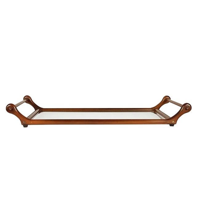 This sculptural serving tray with shaped handles is made from wood, brass and glass tray. It remains in very good condition.