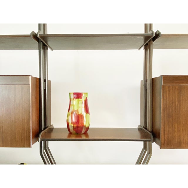 This bookcase was produced in Italy around the 1960s. It consists of 2 main wooden units with shelves and containers,...