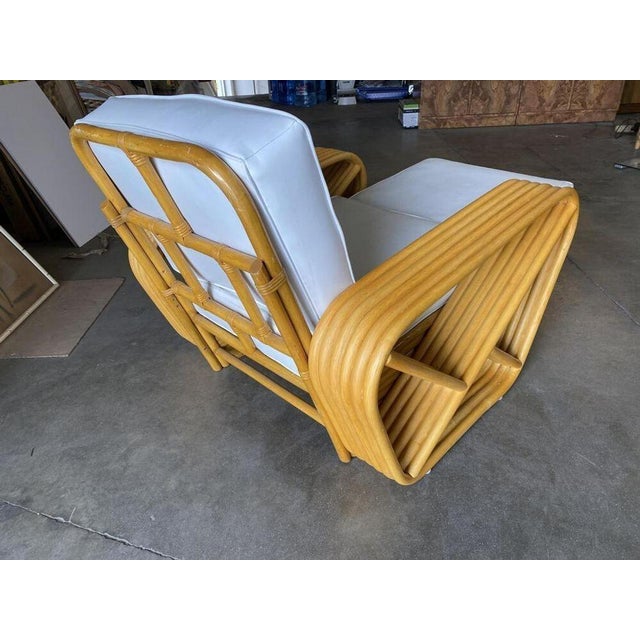 Designed in the manner of Paul Frankl, this six-strand, rattan chaise longue chair features square pretzel arms and a...