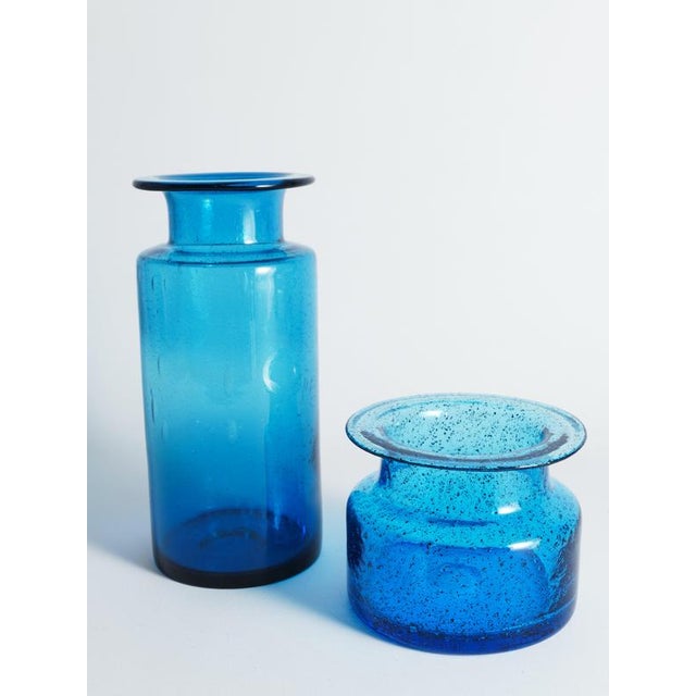 These two vibrant cobalt blue glass vases are striking examples of mid-century Scandinavian design, attributed to the...