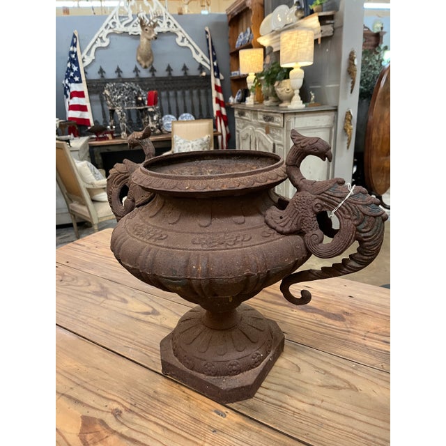 Cast Iron Urn with dragons on each side. Very rusty and cool patina. 9.5 “ opening. Base is 9”x9”