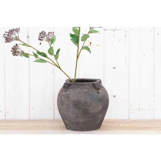 Showing a charming oxidized gray finish, this petite vintage pottery vase has four carved handles on the sides and a...
