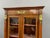 Small Empire-style walnut and cherrywood bookcase, inspired by the Egyptian Revival, opening with two doors. The interior...
