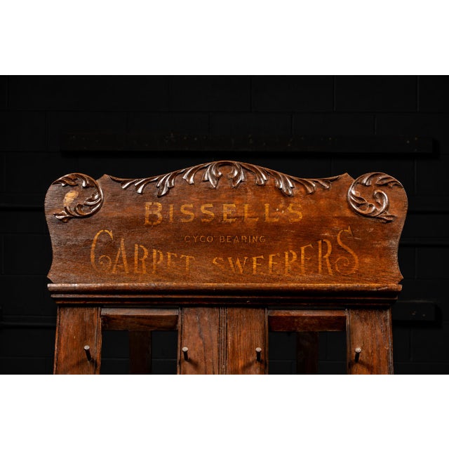 Ornate antique oak store display for Bissell cyco bearing carpet sweepers. Grand Rapids, MI.