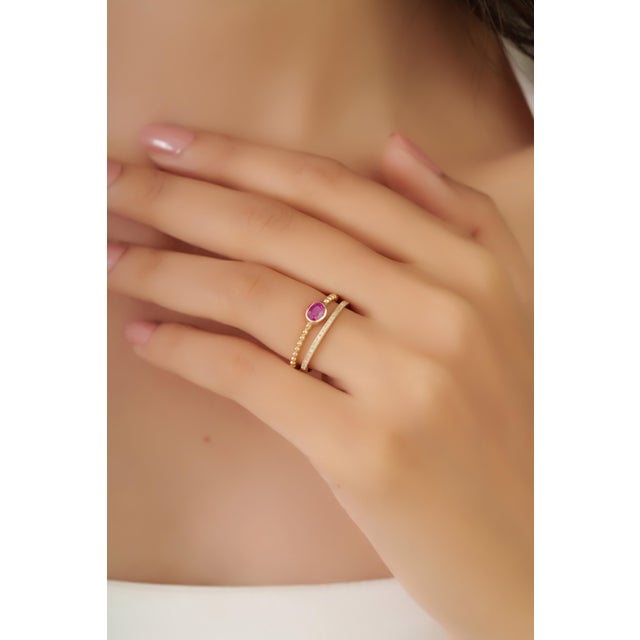 This double-band stacking ring showcases a 0.32 carat ruby set in 14K yellow gold. The ruby measuring 4 x 4.8 mm,...
