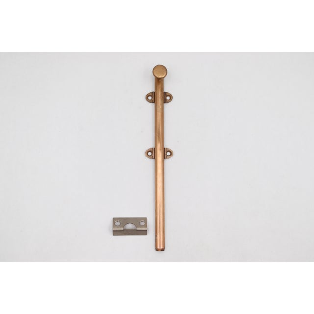 Vintage surface mount slide door bolt made of brass with a polished finish. The original mounting screws are not...