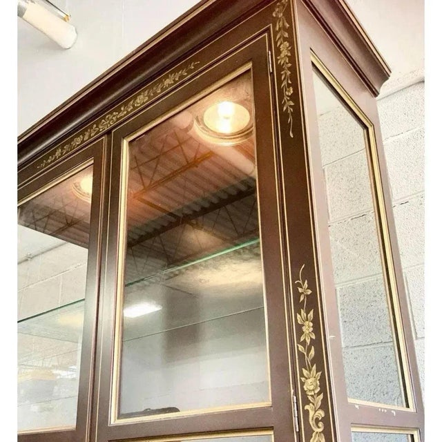 Offered is a vintage brown lacquer display cabinet with chinoiserie painted details. This piece includes three adjustable...