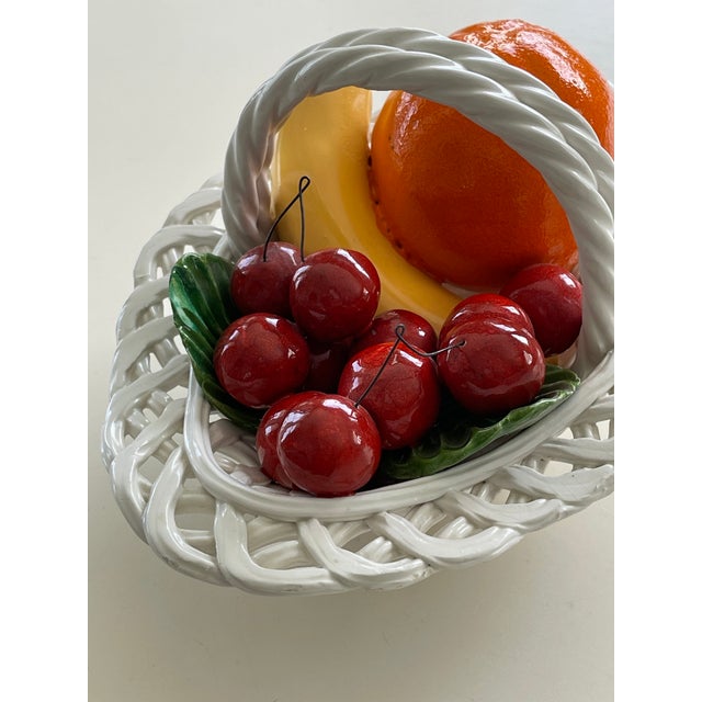 A vintage hand-painted Italian Bassano pottery fruit bo with braided rim and handle. Beautifully woven white basket adorn...