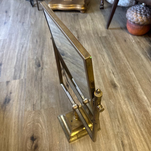 Heavy brass construction with swiveling double-sided mirror, original patina and substantial cast-brass hardware....