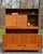 A beautifully crafted vintage mid-century modern cabinet by Caldwell in warm-toned teak, featuring caned cabinet doors and...