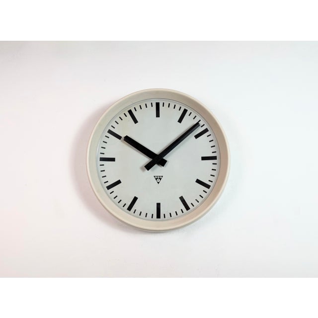 This large wall clock was produced by Pragotron in former Czechoslovakia during the 1960s. It features a beige bakelite...