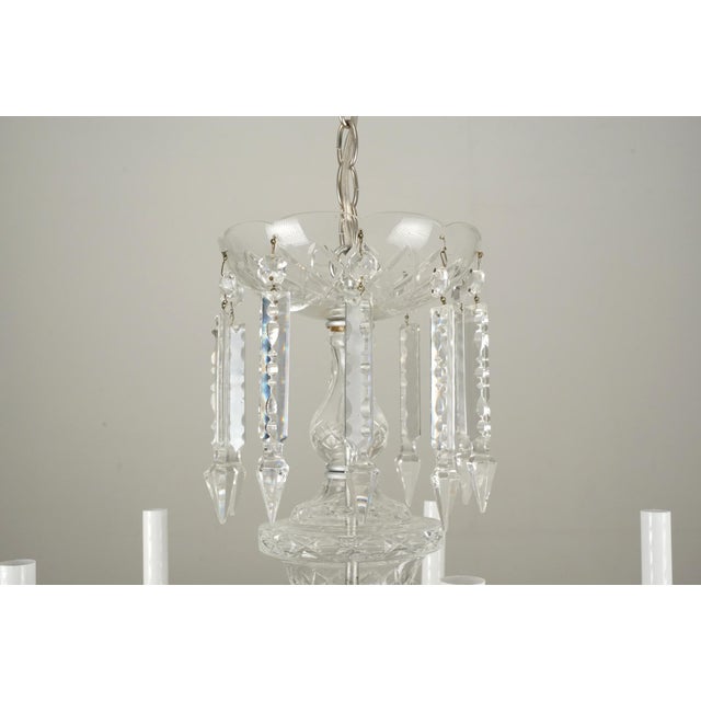 Vintage crystal chandelier with glass arms, bobeches, and crystal drops. There are faceted glass beads and crystal...