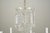 Vintage crystal chandelier with glass arms, bobeches, and crystal drops. There are faceted glass beads and crystal...