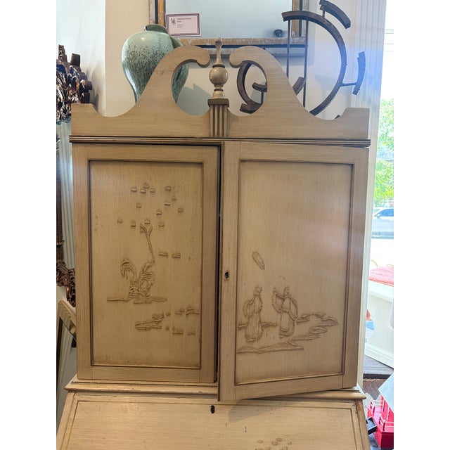 Elegant secretary in a distressed cream finish with hand decorated chinoiserie scenes, a fall front writing surface, upper...
