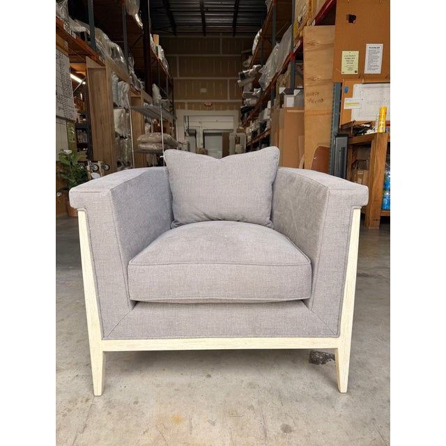 Contemporary accent chair featuring a clean, architectural silhouette upholstered in a soft gray textured fabric for a...