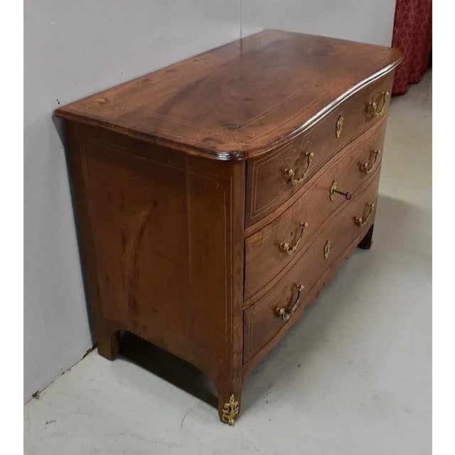 Louis XIV period solid Elm chest of drawers, with a modestly curved front. Its Wooden top is molded on its circumference...
