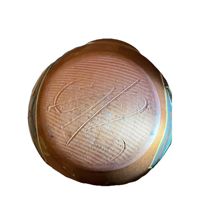 Handcrafted studio pottery pouring bowl signed "GB" on the underside. Wheel-thrown red earthenware form with applied...