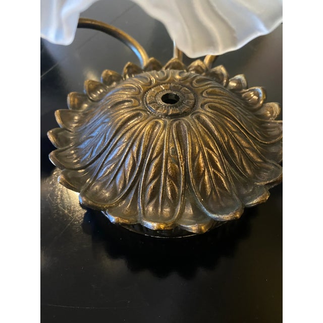 Three light brass sconce with opaque glass shades. Unique flower petal round base Sconce measures 20” across Can be...